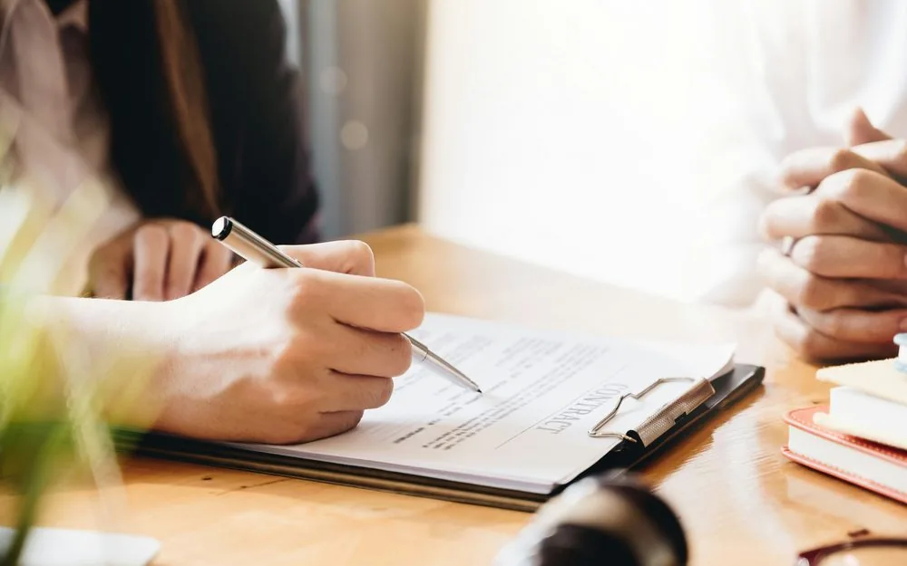 Signing a contract at the closing table